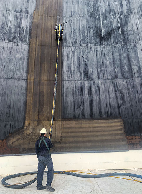 Cleaning oil storage tank with closed waterblasting
